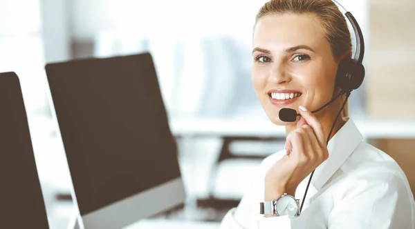 Loira representante de atendimento ao cliente feminino está consultando clientes on-line usando fone de ouvido. Call center e conceito de negócios — Fotografia de Stock