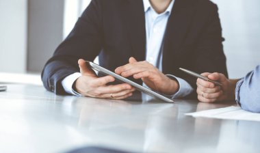 Modern ofiste birlikte çalışırken iş adamları tablet bilgisayar kullanıyorlar. İş yerinde iş arkadaşı olan tanınmamış bir iş adamı ya da erkek girişimci. Takım çalışması ve ortaklık kavramı