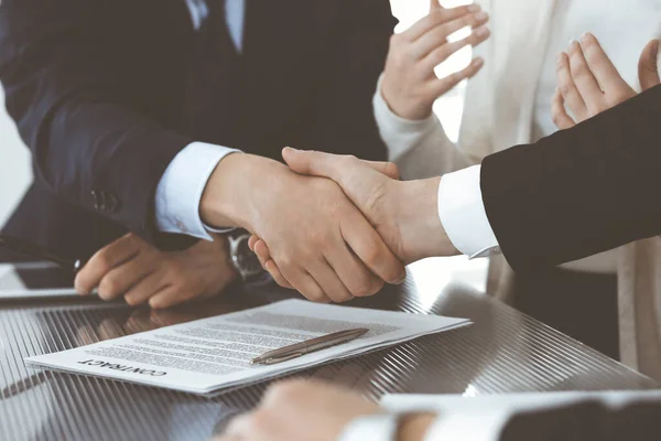 Gente de negocios dándose la mano después de firmar el contrato en la oficina moderna. Trabajo en equipo, asociación y concepto de apretón de manos — Foto de Stock