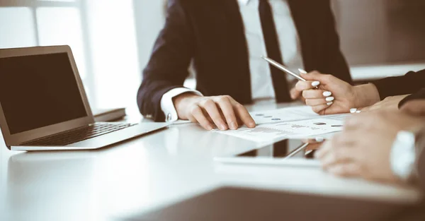 Empresarios y mujeres desconocidos sentados, trabajando y discutiendo preguntas en la reunión en la oficina moderna, primer plano — Foto de Stock