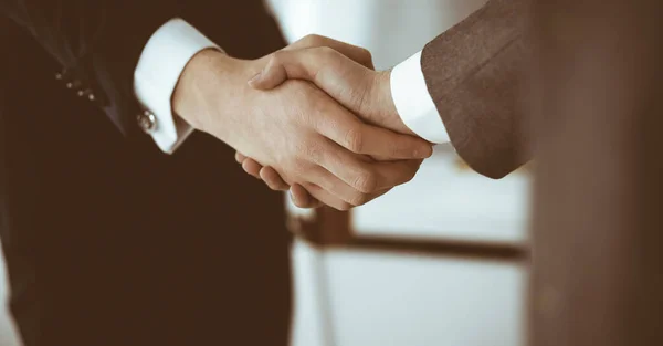Neznámý podnikatel si potřásá rukou se svým kolegou nebo partnerem, když stojí zblízka rovně v moderní kanceláři. Skupina podnikatelů na schůzce — Stock fotografie