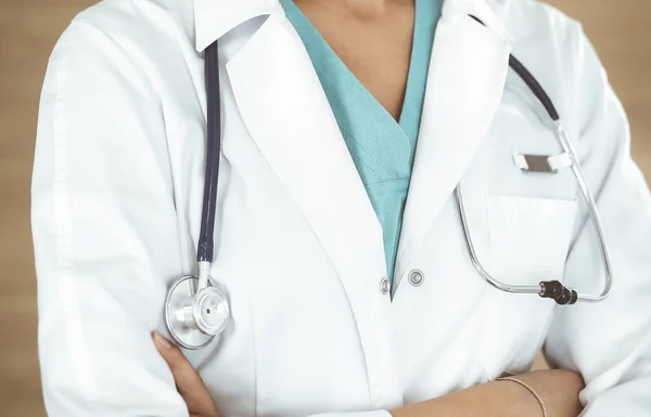 Okänd kvinnlig läkare står med armarna korsade på kliniken, närbild. Medicinskt koncept — Stockfoto