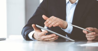 Modern ofiste birlikte çalışırken iş adamları tablet bilgisayar kullanıyorlar. İş yerinde iş arkadaşı olan tanınmamış bir iş adamı ya da erkek girişimci. Takım çalışması ve ortaklık kavramı