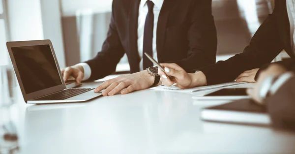 Des hommes et des femmes d'affaires inconnus assis, travaillant et discutant de questions lors d'une réunion dans un bureau moderne, gros plan — Photo