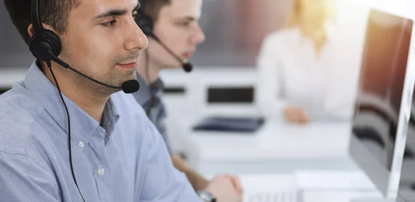 Call center. Group of casual dressed operators at work. Adult businessman in headset at customer service office. Telesales in business — Stock Photo, Image