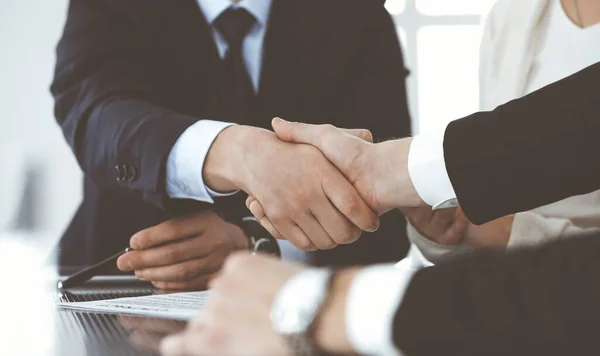 Podnikatelé si potřásají rukama po podpisu smlouvy v moderní kanceláři. Koncept týmové práce, partnerství a potřesení rukou — Stock fotografie