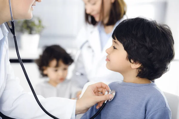 Женщина-врач осматривает ребенка стетоскопом. Милый арабский мальчик на приеме у врача. Концепция медицины — стоковое фото