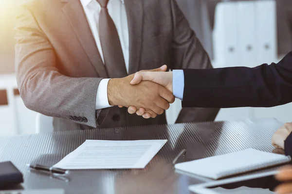 Onbekende zakenmensen schudden elkaar de hand na het tekenen van een contract in een modern kantoor, close-up. Handdruk als succesvol onderhandelingsresultaat — Stockfoto