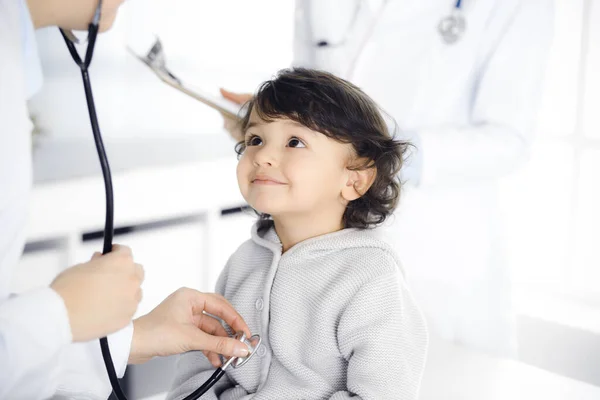 Женщина-врач осматривает ребенка стетоскопом. Милый арабский малыш на приеме у врача. Концепция медицины — стоковое фото