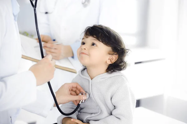 Mujer-médico examinando a un niño paciente por estetoscopio. Lindo niño árabe en la cita con el médico. Concepto de medicina —  Fotos de Stock
