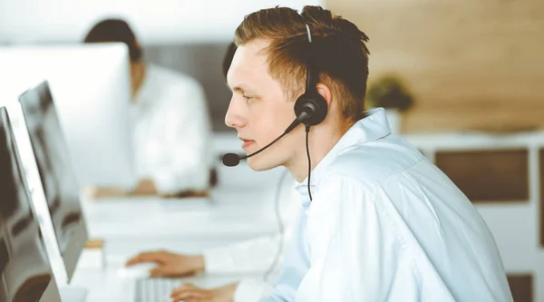 呼叫中心的一组不同的操作员在工作.商人坐在客户服务办公室的耳机里.业务概念 — 图库照片