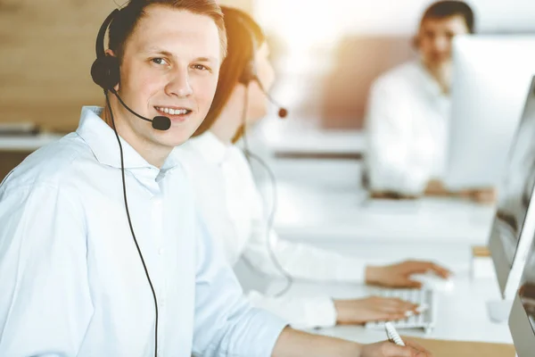 Empresario trabajando en la oficina de servicio al cliente. Grupo de operadores diversos en el trabajo en el centro de llamadas soleado —  Fotos de Stock