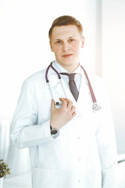 Hombre-doctor parado en una clínica soleada. Concepto de medicina —  Fotos de Stock