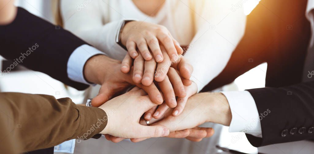 Business people group showing teamwork and joining hands or giving five in sunny office. Unknown businessman and women making circle with their hands