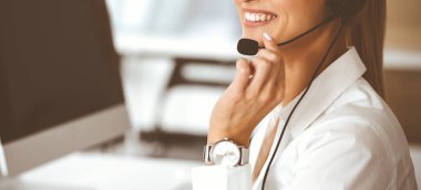 Bilinmeyen kadın müşteri hizmetleri temsilcisi kulaklık kullanarak müşterilere danışmanlık yapıyor. Yakın plan. Çağrı merkezi ve iş konsepti