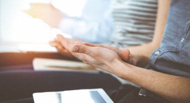 İş adamları toplantı ya da konferansta el çırpıyor. Kimliği belirsiz işadamları ve kadınlar güneşli ofiste.