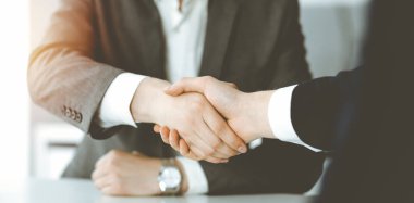 Bilinmeyen işadamı, güneşli ofiste iş arkadaşı ya da ortağıyla el sıkışıyor.