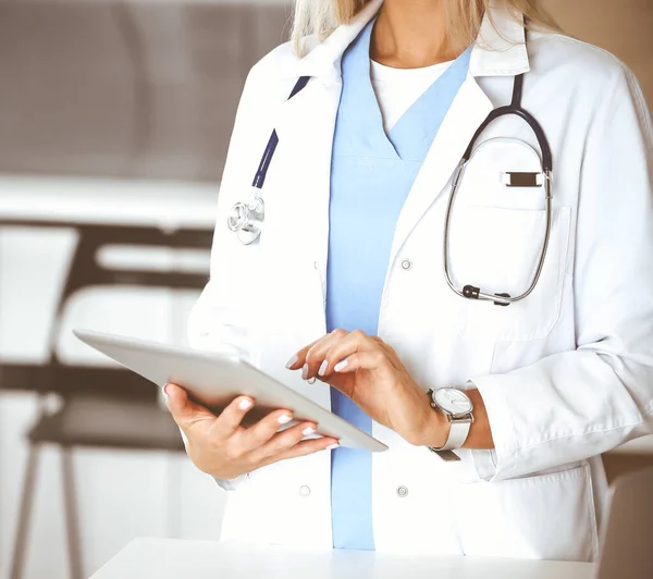 Klinikte çalışan kimliği belirsiz kadın doktor. Tablet bilgisayar kullanan kadın doktor, yakın plan. Tıp konsepti