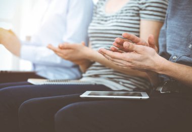 İş adamları toplantı ya da konferansta el çırpıyor. Kimliği belirsiz işadamları ve kadınlar güneşli ofiste.