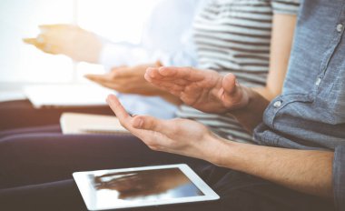 İş adamları toplantı ya da konferansta el çırpıyor. Kimliği belirsiz işadamları ve kadınlar güneşli ofiste.