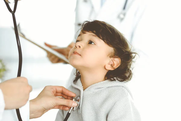 Egy nő-orvos sztetoszkóppal vizsgál meg egy gyermekbeteget. Aranyos arab kisgyerek az orvosi vizsgálaton. Orvosi fogalom — Stock Fotó