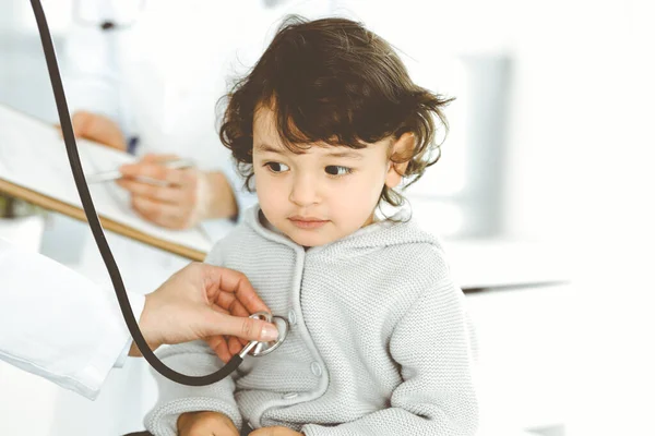 女医生用听诊器检查儿童病人。可爱的arab幼儿在医生预约。医学概念 — 图库照片