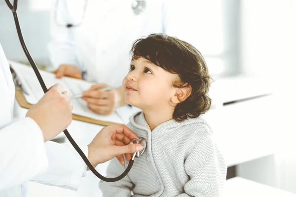 Mujer-médico examinando a un niño paciente por estetoscopio. Lindo niño árabe en la cita con el médico. Concepto de medicina —  Fotos de Stock