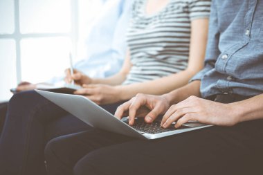 Toplantı ya da konferansta çalışan sıradan giyinmiş iş adamları, ellerinizi yakın tutun. Dizüstü bilgisayar kullanan bir iş adamı. Takım çalışması ya da koçluk kavramı