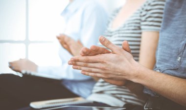 İş adamları toplantı ya da konferansta el çırpıyor. Modern beyaz ofisteki bir grup tanınmayan iş adamı ve kadın. Başarı takım çalışması, kurumsal koçluk ve alkış konsepti