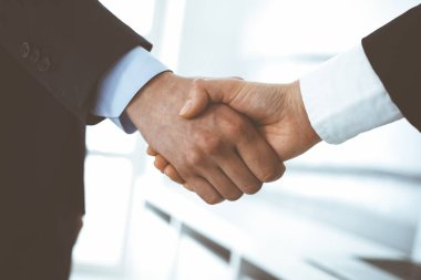 İş adamı ve kadın ofiste el sıkışıyor. İş hayatında başarı sembolü olarak el sıkışma kavramı