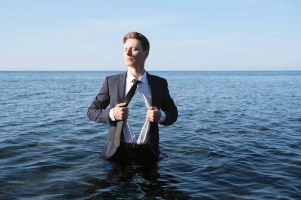 Businessman Standing in Water With Sea Inside a Chest.