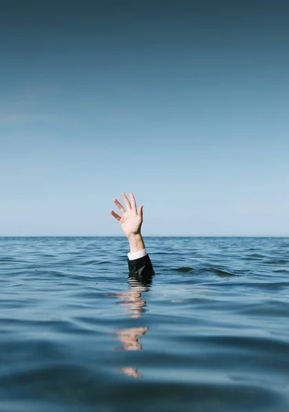 Kurtarma istiyorum. İşadamı Elleri Denizin Üzerinde Yükseldi.