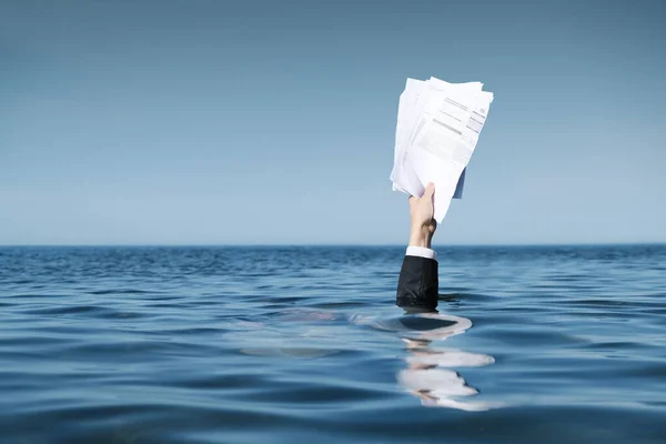 Kurtarma istiyorum. Denizde Boğulan İşadamı. Belgelerle Denizin Üzerinde Yükselen El.