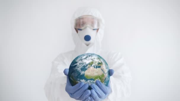 惑星を手に持っている防護服の医者 コロナウイルスの概念 — ストック動画