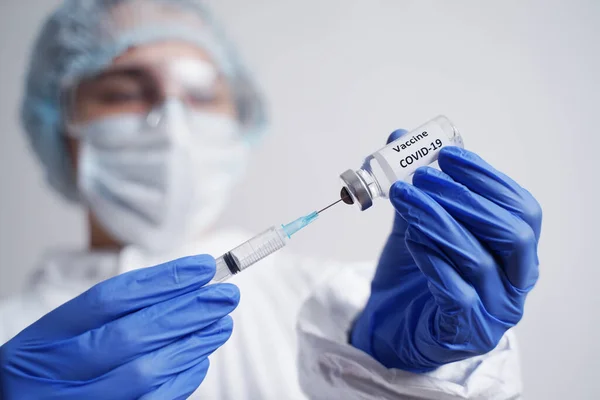 Doktor şırıngayı COVID-19 aşısıyla dolduruyor.