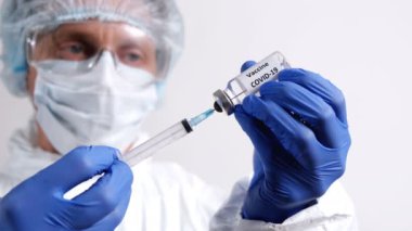 Doktor şırıngayı COVID-19 aşısıyla dolduruyor.