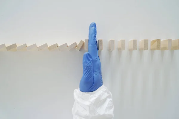 Doktor El, düşen Domino 'yu durdurdu. Salgın Hastalık Konsepti. Üst Görünüm.