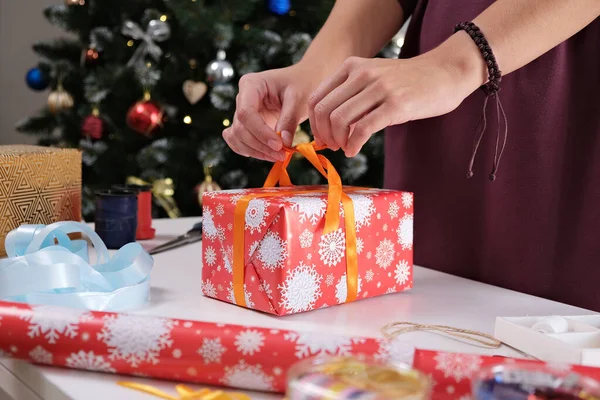 Noel Hediyesi Paketleyen Kadın. Bir Hediye Kutusuna Kurdele Bağlayan Eller.