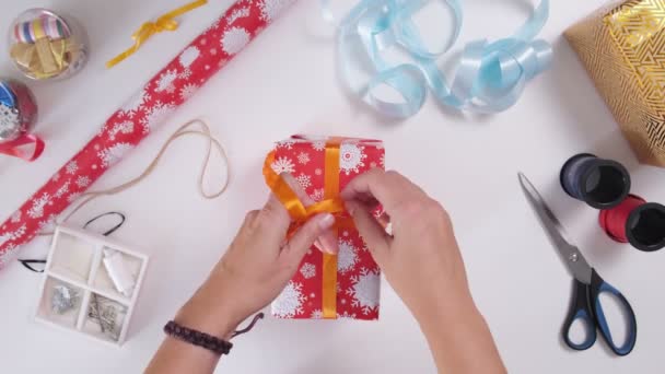 Mulher Embrulhar Presente Natal Mãos Amarrando Uma Fita Torno Uma — Vídeo de Stock