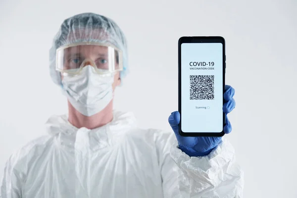 Bir Cep telefonunda Aşılama Kodu Gösteren Doktor.