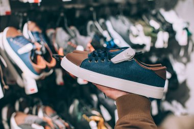 Adam süpermarkette spor ayakkabılarını tutuyor.