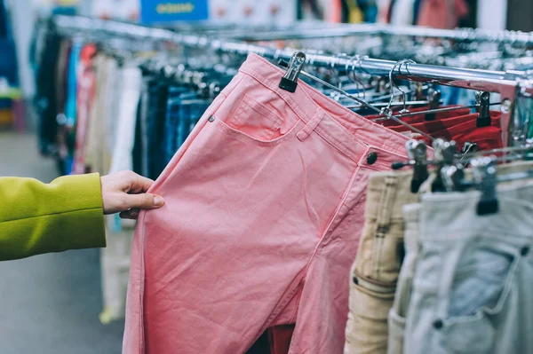 Ragazza Che Tiene Pantaloni Nelle Mani Del Supermercato — Foto Stock