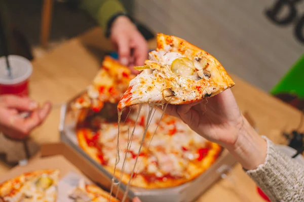 Erkek ve kız pizza yer ve bir içki içerler.