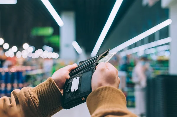 Muž Drží Peněženku Dolary Ruce Pozadí Supermarketu — Stock fotografie