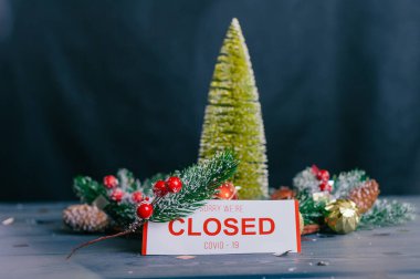 Üzgünüm, kapalıyız. Yeni yıl ve Noel için şenlikli kompozisyon. Tahta bir masanın üzerindeki süslemeli Noel ağacı