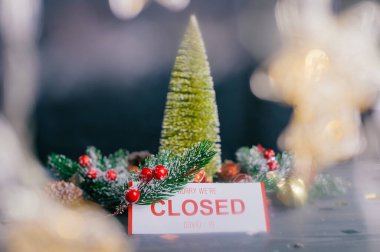 Üzgünüm, kapalıyız. Yeni yıl ve Noel için şenlikli kompozisyon. Tahta bir masanın üzerindeki süslemeli Noel ağacı