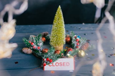 Üzgünüm, kapalıyız. Yeni yıl ve Noel için şenlikli kompozisyon. Tahta bir masanın üzerindeki süslemeli Noel ağacı
