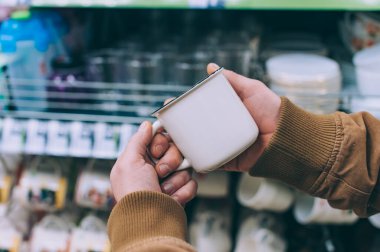 Süpermarketteki adam elinde bir bardak tutuyor.