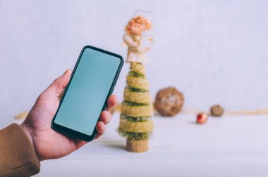 Model teknolojisi. Adamın elinde şenlikli bir arka planda akıllı bir telefon var.