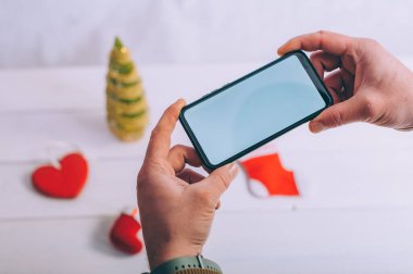 Model teknolojisi. Adamın elinde şenlikli bir arka planda akıllı bir telefon var.